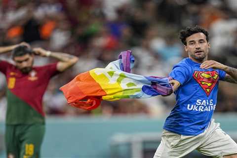 Protester with a rainbow flag runs onto the field at the World Cup