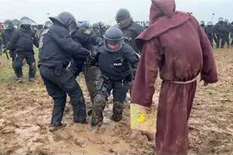 Man dressed as wizard confronts riot police stuck in the mud