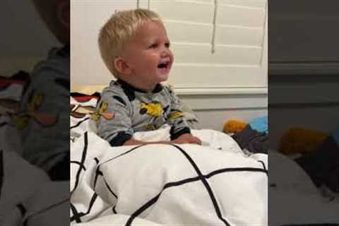 Boy can't control laughter at dad's bed time game