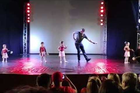 Loving dad helps shy daughter with ballet steps on stage